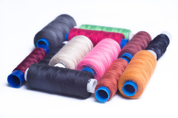 Spools of thread stacked square on a white background