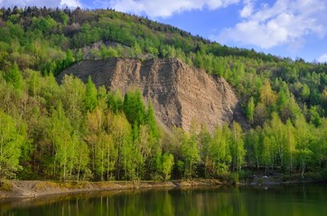 Fototapeta na wymiar Beautiful spring mountain landscape. Quarry in the mountains by the lake.