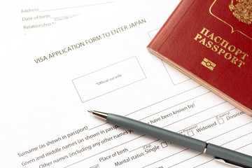 Pen and passport on blank Japan visa application form. Tourism and travel in Japan concept.