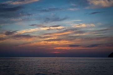 Obraz premium The sun disappearing behind the sea