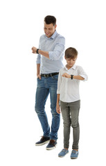 Portrait of dad and his son checking time isolated on white