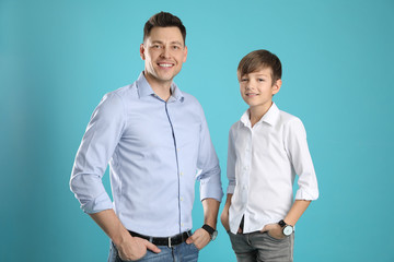 Portrait of dad and his son on color background