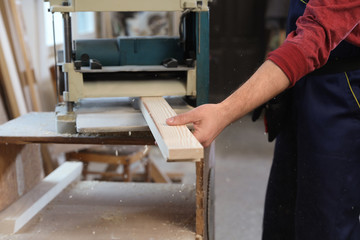 Working man using thickness planer at carpentry shop, closeup