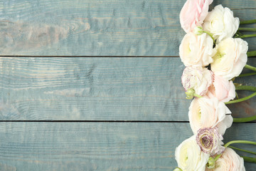 Beautiful ranunculus flowers and space for text on wooden background, flat lay