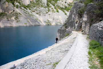 Man walking near the blue lake. Croatia, Imotski, Blue lake