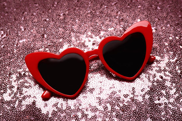 Red heart shaped sunglasses on bright background