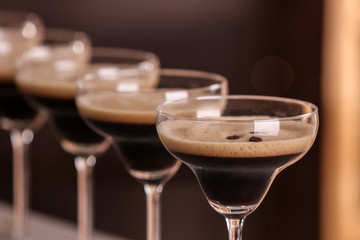 Glasses of delicious Espresso Martini on blurred background. Alcohol cocktail