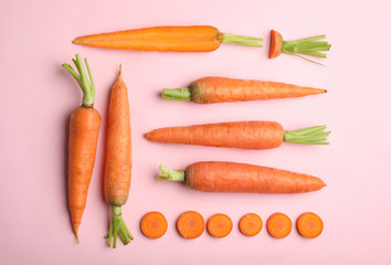 Flat lay composition with fresh carrots on color background