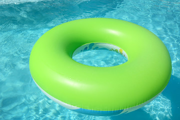 Fototapeta na wymiar Bright inflatable ring floating in swimming pool on sunny day