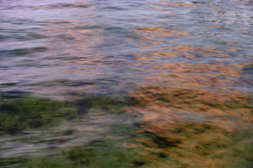 The clear waters of the Florida Keys reflect the orange clouds at sunset with a clear view to the bottom
