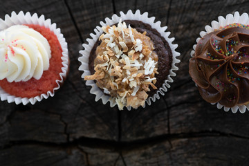 Three cupcakes on a wooden background