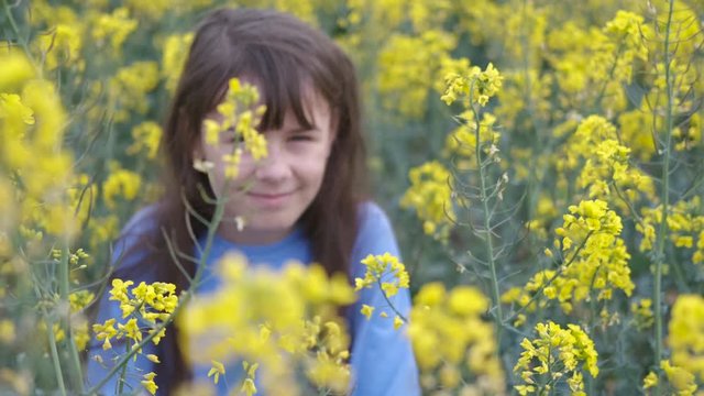 Happy teen girl in yellow canola colors. A young girl in a blooming yellow field.