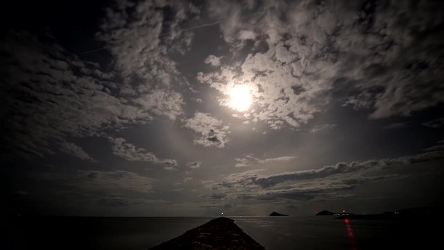 beautiful slowly lunar beam ring time lapse above the sea of Chom Phon, Thailand in cloudy night video 4k stock