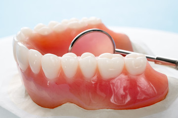 Close up , Complete denture or full denture on blue background.