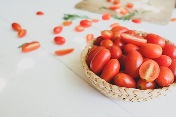 Fresh tomatoes and rosemary on a white background.