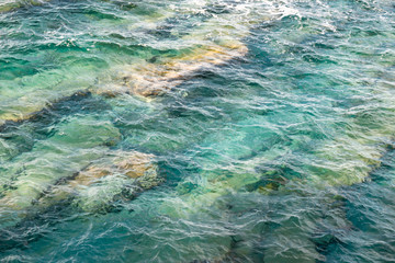beautiful sea water texture design detail with rocks and beautiful emerald green turquoise color, close up