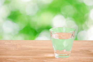 Glass of water on the table. Nature background.  テーブルの上にあるグラス一杯の水と自然背景