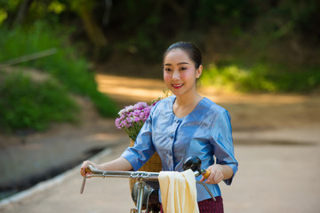 Obraz premium Beautiful woman with red bike And the flower basket on the bridge
