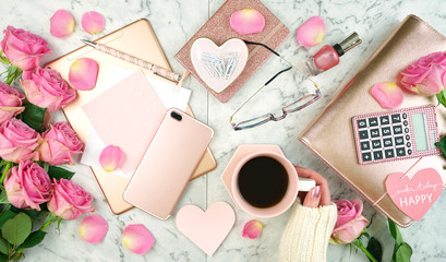 Fototapeta na wymiar Ultra feminine pink desk workspace with rose gold accessories on white marble background flatlay overhead.
