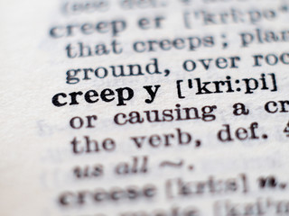 Dictionary definition of word creepy. Selective focus.
