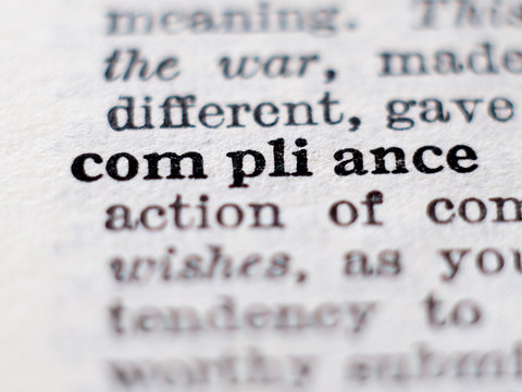 Dictionary definition of word compliance. Selective focus.