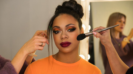 Portrait stylish African American. Girl posing in beauty salon with high hairstyle and make-up...