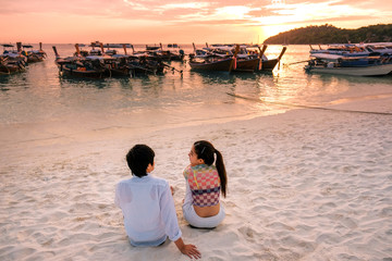 Couple relaxing beautiful sunset on Koh Lipe Beach Thailand ,Summer vacation