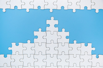 Unfinished white jigsaw puzzle pieces on blue background, The last piece of jigsaw puzzle, Copy...