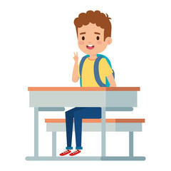 happy little student boy seated in school desk