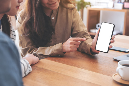 Woman Holding And Showing Mockup Mobile Phone To Friends