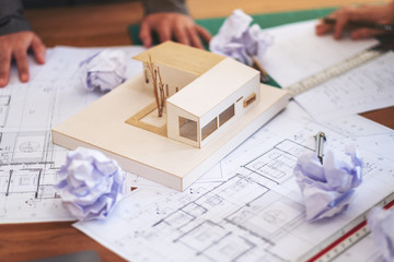 Group of an architect failed while working on architecture model and shop drawing paper with...