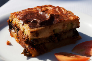 National Greek food Moussaka eggplant and minced meat. On white plate.