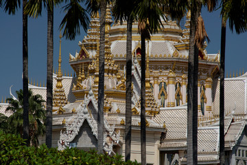 Beautiful exterior of Buddhist temple with coconut tree in foreground
