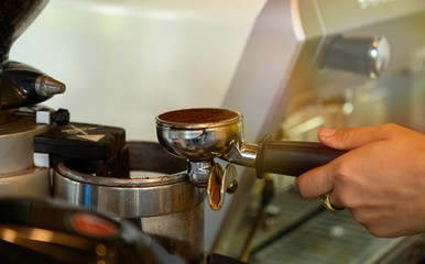 Closeup  Espresso pouring ground coffee in coffee shop.