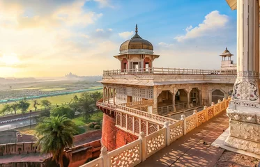 Poster Agra Fort - Medieval Indian fort made of red sandstone and marble with view of dome at sunrise. View of Taj Mahal at a distance as seen from Agra Fort. © Roop Dey