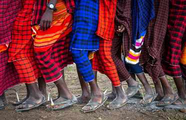 feet of maasai warriors walking in a roe