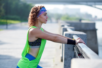 Fitness healthy woman runner relaxing after running outdoors enjoying view on waterfront