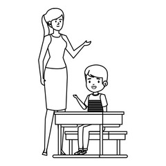 student boy seated in school desk with female teacher