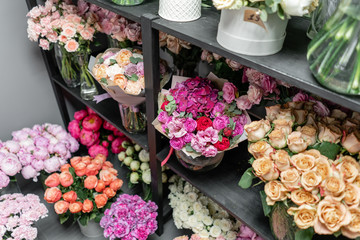 Vases with different colored flowers, showcase flower shop. Beautiful spring bouquets. . Small family business. Work florist. copy space