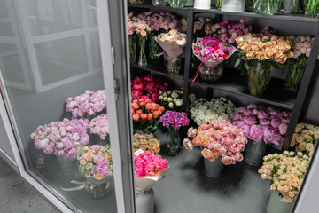 Vases with different colored flowers, showcase flower shop. Beautiful spring bouquets. . Small family business. Work florist. copy space