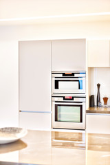 Modern kitchen with cupboards and silver ovens