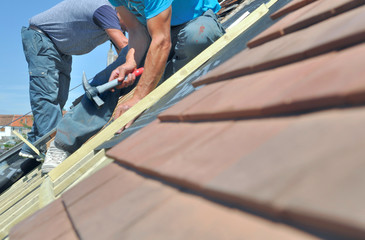 roofers working at the top of a house  for renovation - obrazy, fototapety, plakaty