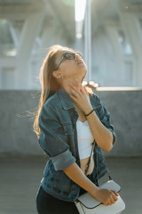Fototapeta premium Beautiful young girl on the streets of modern town in glasses. Leisure, beauty, fashion concept