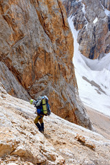 climber with equipment on the slopes climbs on ropes