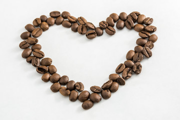 Coffee beans in the shape of a heart on a white background. Concept of freshness or great aroma and energy. Concept of Valentine's day.