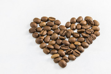 Coffee beans in the shape of a heart on a white background. Concept of freshness or great aroma and energy. Concept of Valentine's day.