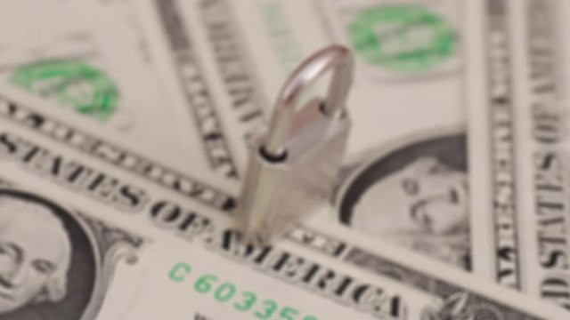 Padlock on dollar bills. Financial frauds concept.