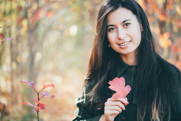 Female beauty portrait surrounded by vivid foliage. Dreamy beautiful girl with long natural black...