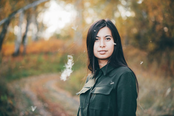 Dreamy beautiful girl in airy white fluff on bokeh background with yellow leaves. Inspired girl in...