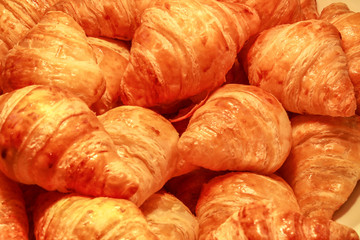 Fresh Croissants on a Dish Selective Focus, croissant close up view in the bakery, warm tone, food background
